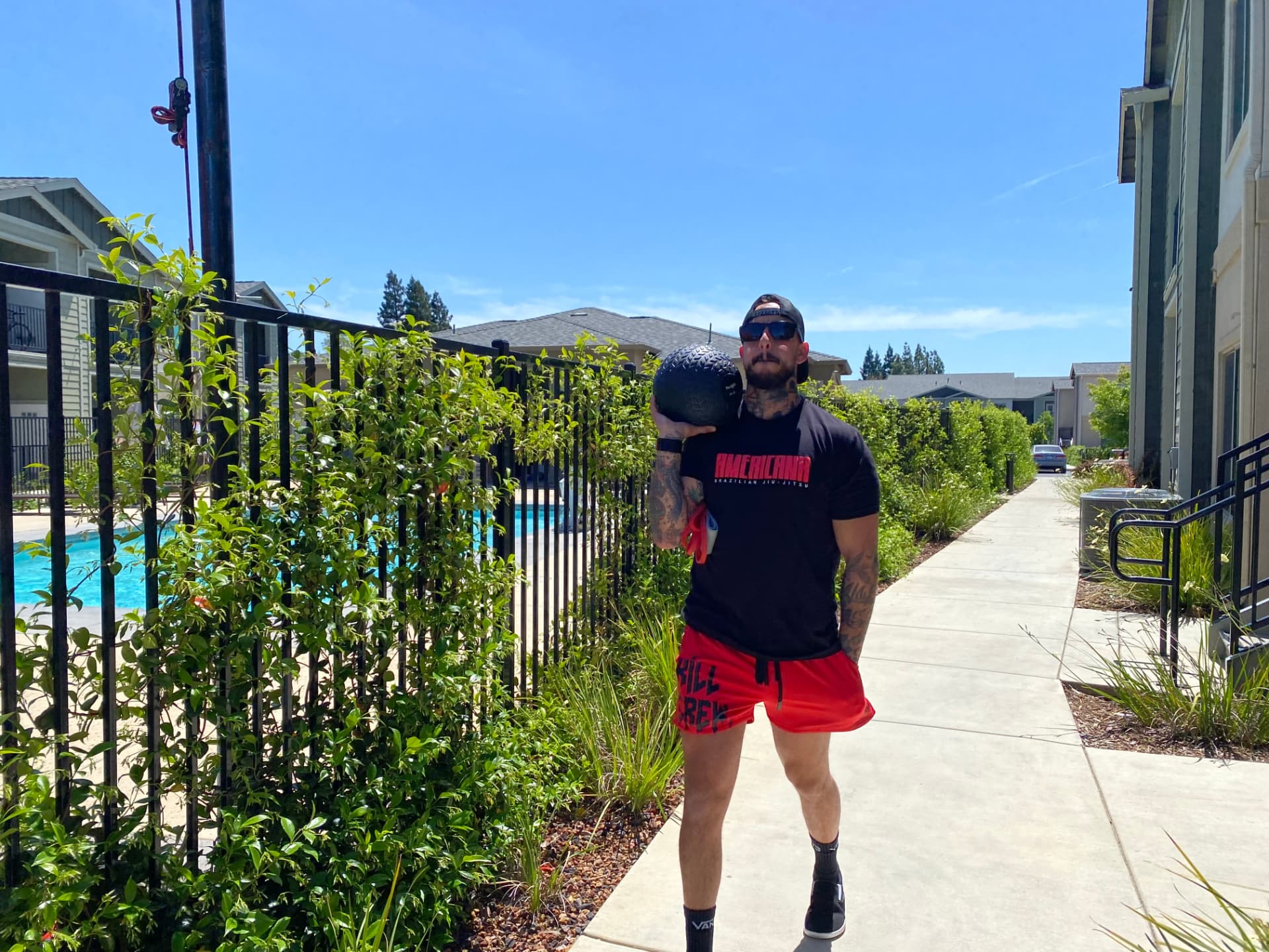 James Biccum, owner of Gym Truck Chico, holds a medicine ball outdoors during a mobile personal training session in Chico, CA, bringing a decade of certified fitness coaching experience to clients at home, work, or local parks.
